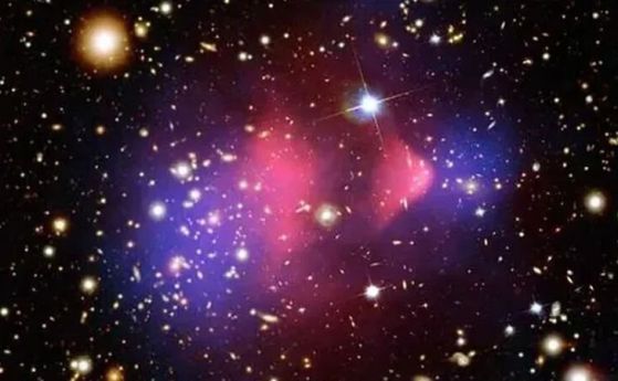 Съставно изображение на клъстера Куршум (Bullet), добре проучена двойка галактически купове, които са се сблъскали челно. Единият е минал през другия, подобно на куршум, преминаващ през ябълка, и се смята, че показва ясни признаци на тъмна материя (синьо)