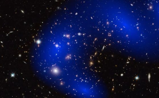 Изображение на галактическия клъстер MACSJ0717.5+3745 с хиляди галактики в четири отделни подкупа. Сините контури показват изведеното разпределение на масата от ефектите на гравитационните лещи върху фонови обекти.  