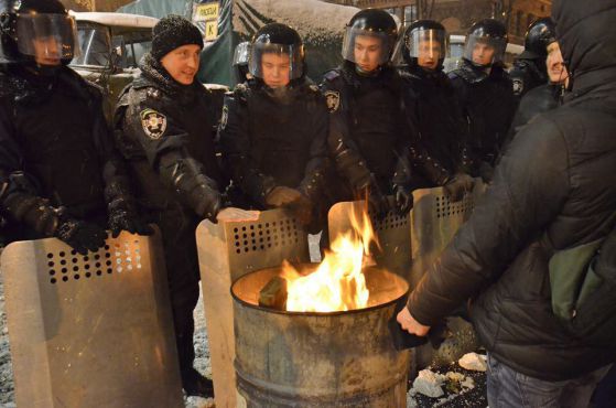 Полиция и протестиращи се топлят по време на протеста в Киев на  10.12.2013. Снимка : Тихомира Методиева