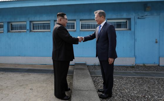 Севернокорейският лидер Ким Чен Ун (вляво) и южнокорейският президент Мун Дже-Ин (вдясно) се ръкуват над военната демаркационна линия по време на междукорейска среща на върха на 27 април 2018 г. в Панмунджом, Южна Корея.