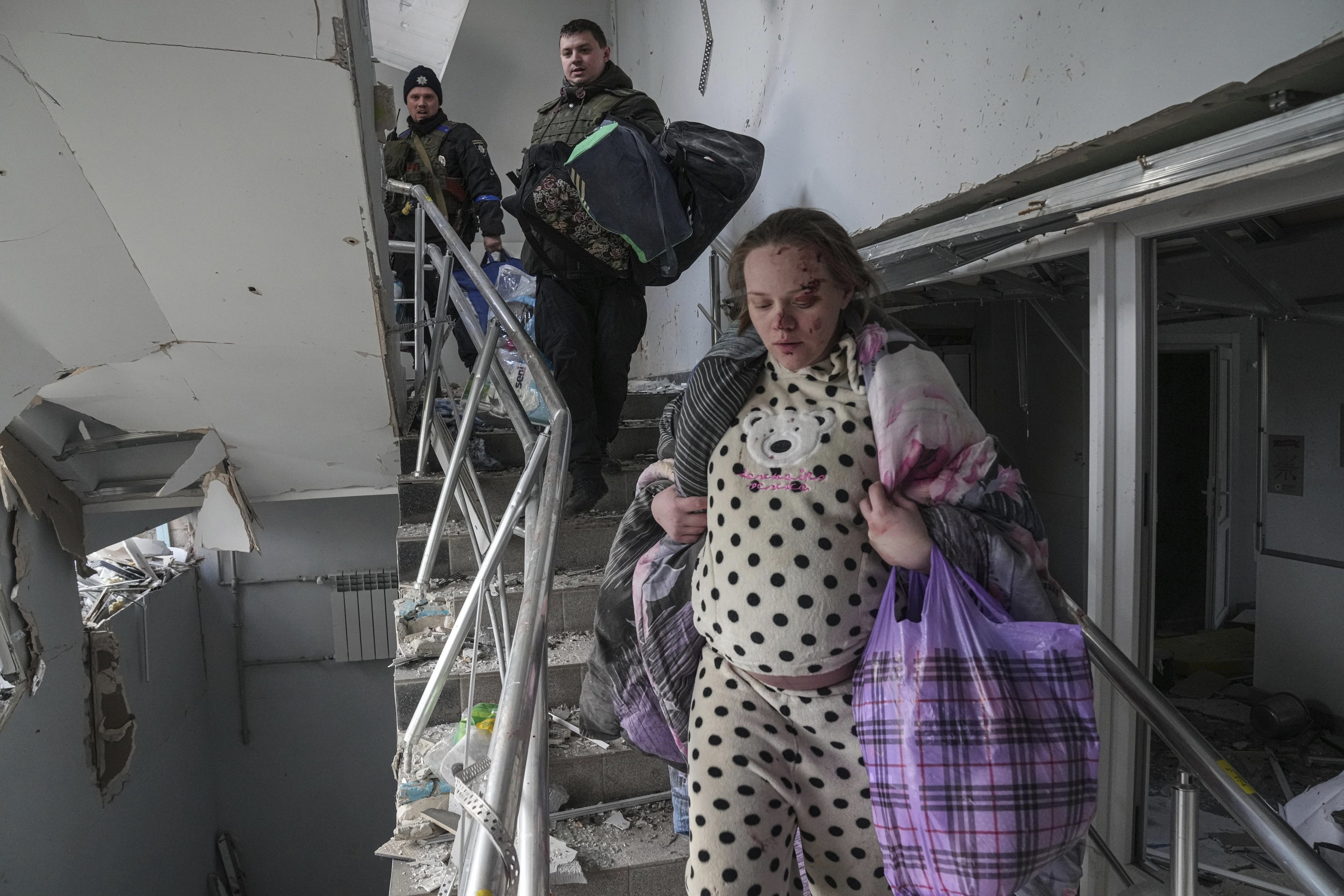 Снимка на тежко бременна жена бягаща от бомбардиран родилен дом