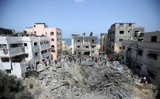 Палестинци оглеждат ямата останала след ракетен удар от Израел в западната част на Газа