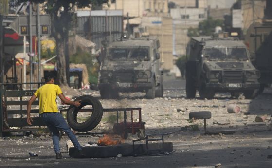 Палестински демонстрант гори гуми по време на сблъсъци с израелската армия, докато силите провеждат операция в град Наблус на Западния бряг, вторник, 9 август 2022 г.