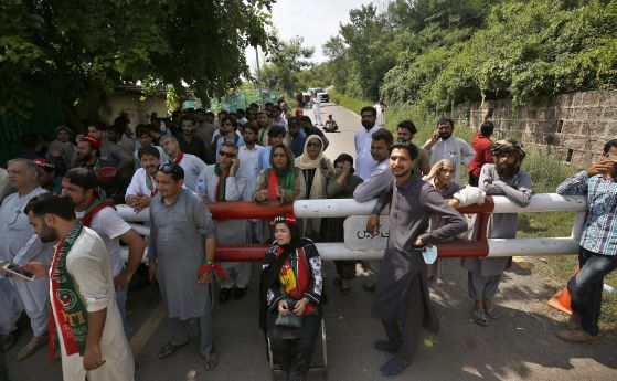 Привърженици на партията на бившия пакистански премиер Имран Хан се събират пред резиденцията му в Исламабад, Пакистан, понеделник, 22 август 2022 г., след като пакистанската полиция повдигна обвинения в тероризъм срещу Хан и това доведе до политическото 