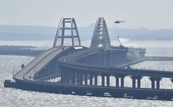 Хеликоптер изсипва вода върху Кримския мост, за да потуши пламъците след взрива на камион на 8 октомври 2022 г.