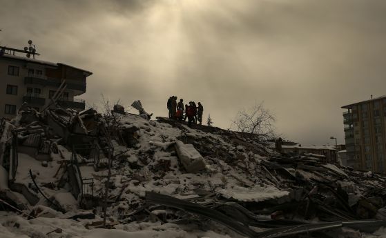 Спасители търсят тела и живи хора под отломките от разрушена от земетресението в Турция сграда в Малатия.