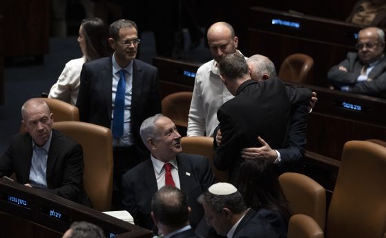 Министър-председателят на Израел Бенямин Нетаняху (в средата) и депутати поздравяват министъра на правосъдието Ярив Левин (с гръб към камерата) след речта му в израелския парламент, Кнесета, точно преди гласуването на спорния план за преразглеждане на пра