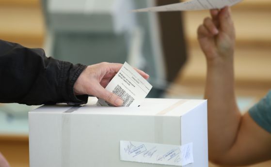 Избирател пуска в кутия разписката си от машинно гласуване.
