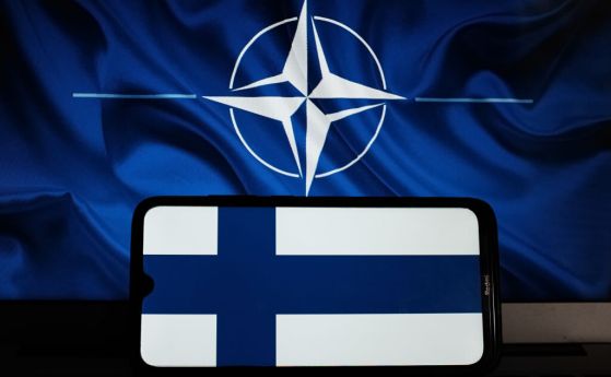 Знамето на Финландия на екрана на смартфон и знамето на НАТО.