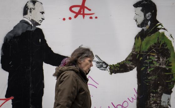 Жена минава покрай графит, изобразяващ президентите на Русия и Украйна Владимир Путин и Володимир Зеленски, в централен Лондон, 4 май 2023 г.