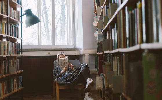 Студентка чете в библиотека.