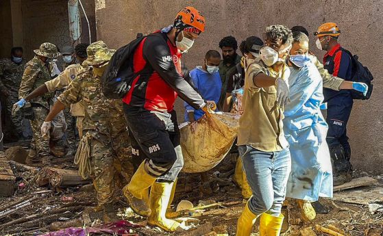 Турски спасители носят тяло, извадено от водата край либийския град Дерна.