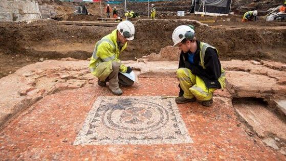 Археолози коленичат до римска мозайка, открита в центъра на Лондон.