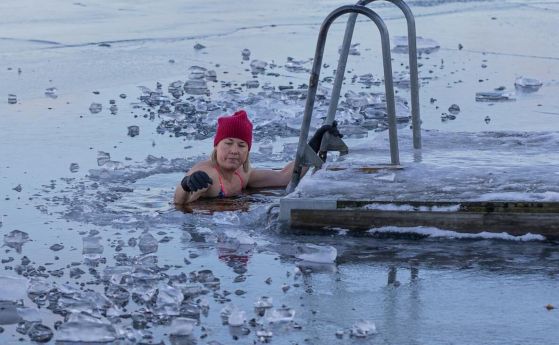 жена излиза от басейн, покрит с ледени късове