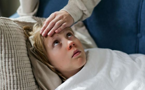 момиче с висока температура лежи на дивана
