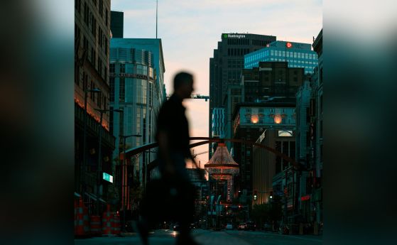 тъмен, размазан силует на човек, крачещ в голям град