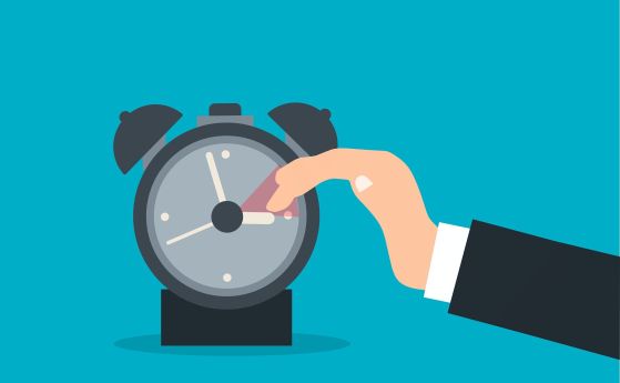 ръка отмества стрелката на будилник