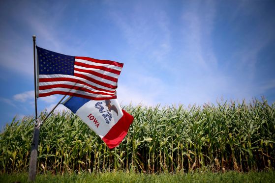 FILE PHOTO: A U.S. and Iowa state flag are seen next to a corn field in Grand Mound
