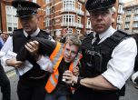 Британски полицаи арестуват един от протестиращите в защита на Джулиан Асандж пред посолството на Еквадор в Лондон. Снимка: EPA/БГНЕС