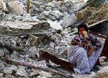 Жена седи върху отломките от сграда, разрушена от силното земетресение в Иран на 9 април 2013 г. Снимка: EPA/БГНЕС