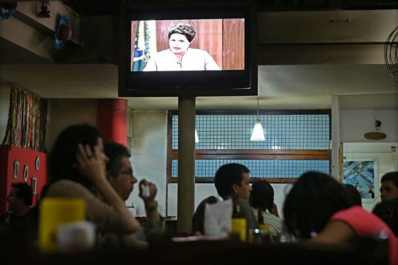 Бразилската телевизия излъчва обръщението на президента Дилма Русеф към протестиращите. Снимка: ЕПА/БГНЕС