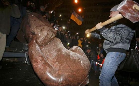 Протестиращи събориха и строшиха с чукове паметника на Ленин в центъра на Киев. Снимка: Ройтерс