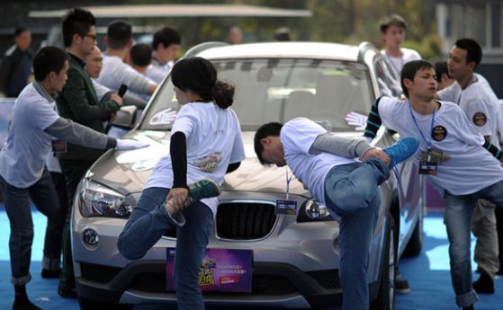 Китаец стоя 7 часа и 26 минути на един крак, за да спечели BMW (снимки)
