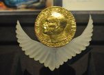 Златен медальон с изобразен Алфред Нобел в ляв профил.