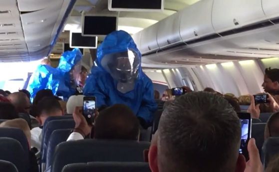 Медицински лица в предпазни костюми претърсват самолета.