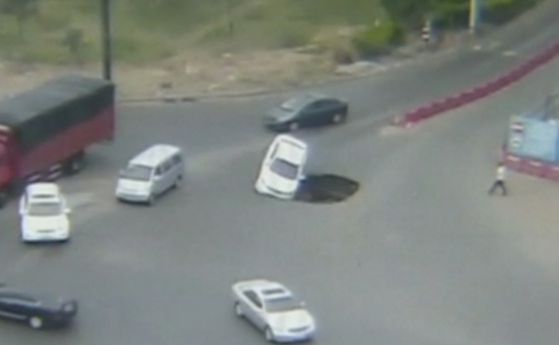 Гигантска дупка на пътя погълна кола в Китай (видео) 