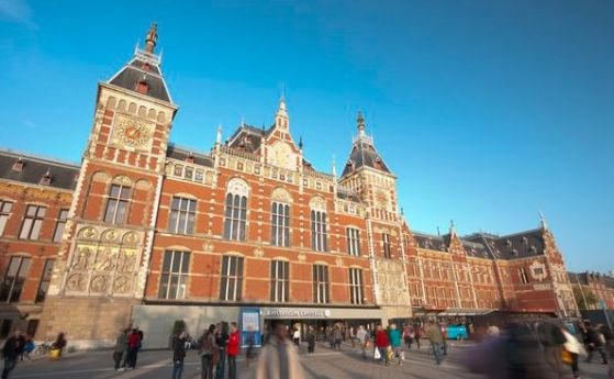 Мъж намушка двама на гарата в Амстердам