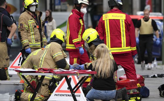 Пожарникари и медици помагат на ранен, след като кола се вряза в пешеходци в Берлин.
