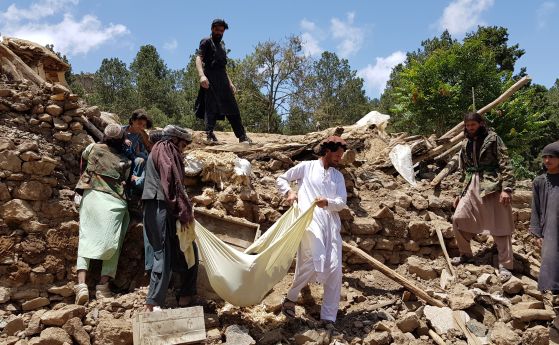 Мъже носят мъртво тяло, извадено от отломките на сграда след земетресението в Афганистан