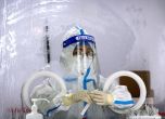 Служител, облечен в защитен костюм, чака да направи тест за COVID-19 в център за тестване на коронавируси в Пекин, сряда, 6 юли 2022 г. На жителите на части от Шанхай и Пекин бе наредено да преминат през допълнително тестване за COVID-19 след откриването 