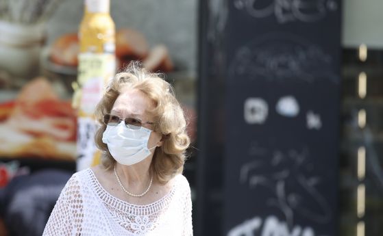 Жена с маска на улицата