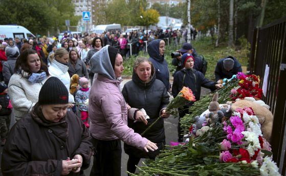 Хора се събират, за да положат цветя, да поставят играчки и да запалят свещи в памет на жертвите на стрелбата в училище № 88 в Ижевск, Русия, понеделник, 26 септември 2022 г.