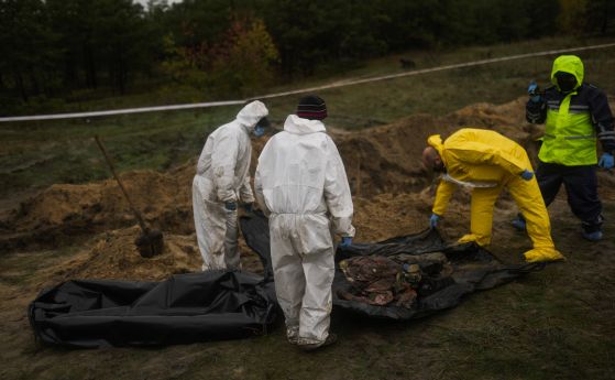 Членове на съдебномедицински екип работят по време на ексхумация на масов гроб в Лиман, Украйна, вторник, 11 октомври 2022 г. 