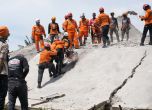 Спасители пробиват цимент, за да извадят тялото на жертва на земетресение изпод развалините на срутена сграда в Сианжур.