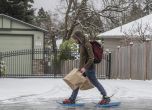 Конър Синот излиза от магазина за хранителни стоки, обут в обувки за сняг с шипове в петък, 23 декември 2022 г., Сиатъл. 