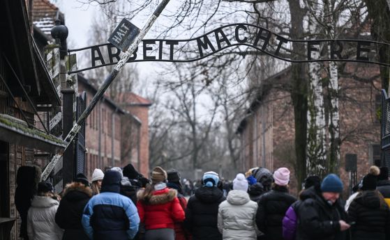 Посетители минават покрай главната порта на бившия концентрационен лагер Аушвиц с мотото Arbeit Macht Frei (Работата носи свобода). 26 януари 2023 г., Освиенцим, Полша.