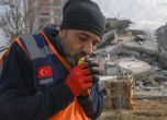 Турски спасител целува малка птичка - папагал буджеригар, извадена жива изпод руините.
