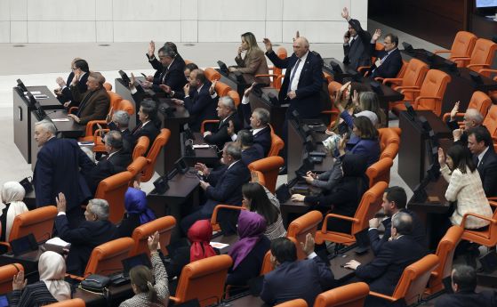 Турски депутати от управляващата Партия на справедливостта и развитието гласуват в подкрепа на кандидатурата на Финландия за членство в НАТО, късно в четвъртък, 30 март 2023 г., в парламента в Анкара, Турция.
