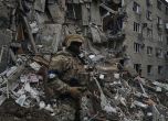 Украински войник пред разрушена жилищна сграда.