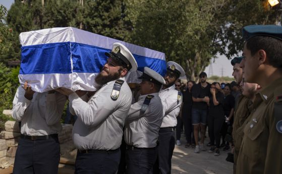 Израелски войници носят ковчег, покрит с израелското знаме, по време на погребението на Ерик Крауник, началник на охраната на кибуц Беери, в гробището Йехуд, Централен Израел, понеделник, 23 октомври 2023 г. Крауник е убит от бойци на Хамас в кибуц Беери 