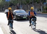 Велосипедисти се движат пред електрически автомобил в Китай