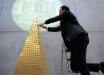 03 December 2024, Bavaria, Munich: Benjamin Summa, employee at pro aurum, places a gold coin in the gold Christmas tree. In cooperation with the Austrian Mint, the precious metal dealer is presenting the gold tree, which consists of 2,024 Vienna Philharmo