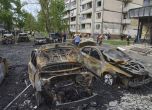 Общински работници почистват изгорели автомобили в жилищен район след руската атака с дрон в Киев, 4 май 2025 г. Снимка: АП/Efrem Lukatsky