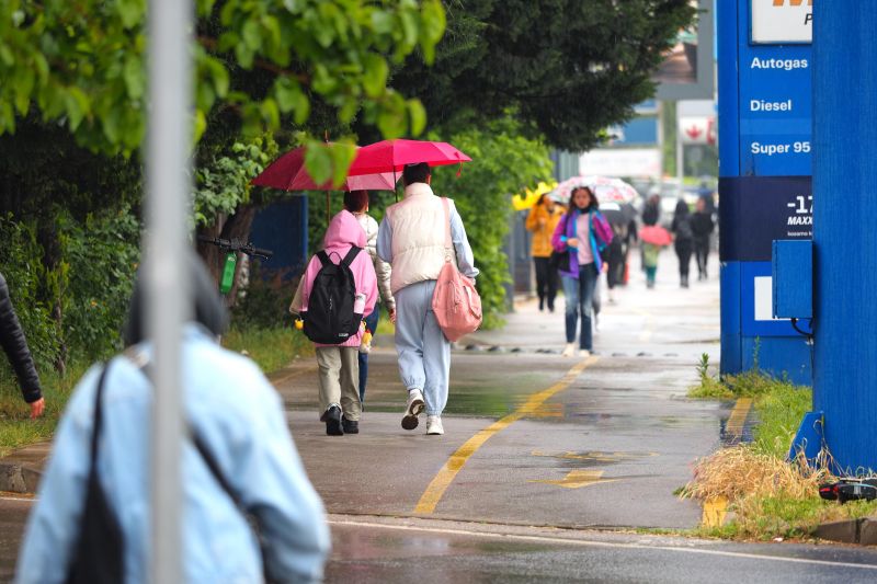 Пешеходци с чадъри по велоалеите в София