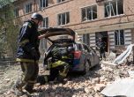 Служители на екипи за спешна помощ вчера след руски удар в украинския град Харков. Снимка: АП/Andrii Marienko