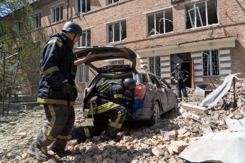 Служители на екипи за спешна помощ вчера след руски удар в украинския град Харков. Снимка: АП/Andrii Marienko